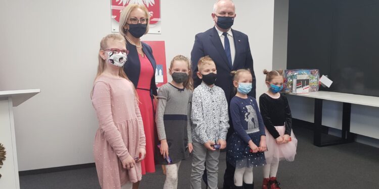 Kwiaty i znicze pod tablicą